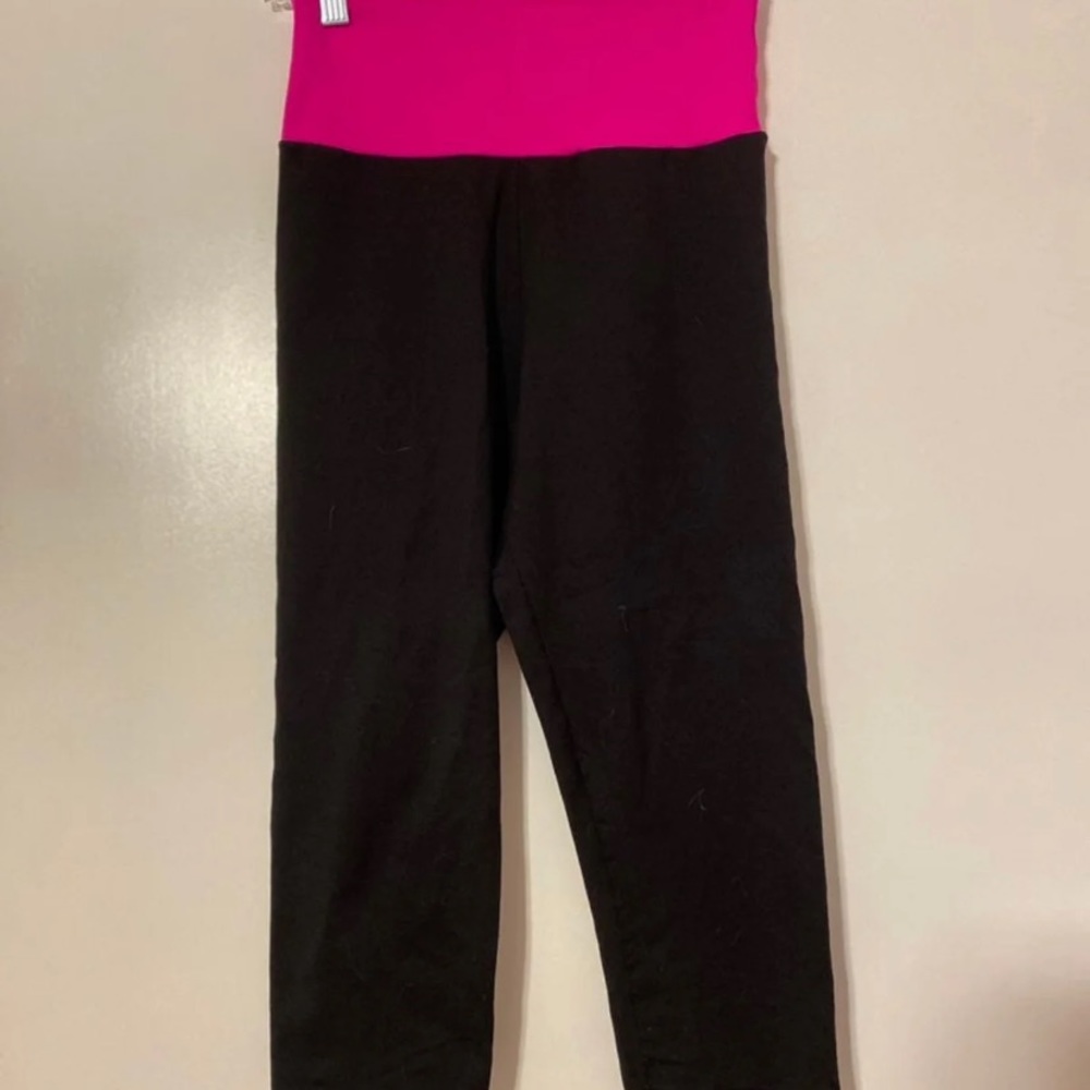 Black athletic pants with a pink band.